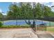 Outdoor tennis court with green and blue surface, surrounded by fencing and lush greenery at 1545 Center Cross Pass, Marietta, GA 30062