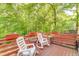 Large deck features plenty of seating and a wooded view at 1720 Alcovy River Dr, Dacula, GA 30019