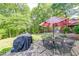 Outdoor patio area featuring a table, chairs, and grill with wooded backdrop at 1720 Alcovy River Dr, Dacula, GA 30019