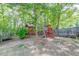 Backyard features a wood playground set and mature trees at 1720 Alcovy River Dr, Dacula, GA 30019