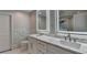 Modern bathroom featuring dual sinks, illuminated mirrors, marble countertop, tile backsplash and flooring at 194 Jennifer Nw Ln, Lilburn, GA 30047