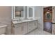 Bathroom featuring dual sinks, illuminated mirrors, marble countertop, tile backsplash and flooring at 194 Jennifer Nw Ln, Lilburn, GA 30047