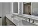 Modern bathroom with double vanity, illuminated mirrors, and white countertop at 194 Jennifer Nw Ln, Lilburn, GA 30047