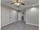 Bedroom featuring wood-look flooring, neutral walls, ceiling fan, and double closet doors at 194 Jennifer Nw Ln, Lilburn, GA 30047