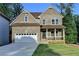 Charming two-story brick home featuring a covered front porch and attached two-car garage at 194 Jennifer Nw Ln, Lilburn, GA 30047