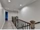 Upstairs hallway with wood-look flooring, neutral paint, and iron railing overlooking the stairs at 194 Jennifer Nw Ln, Lilburn, GA 30047
