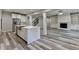 Open-concept kitchen with white cabinets, marble island, stainless appliances, and view to the living room and stairs at 194 Jennifer Nw Ln, Lilburn, GA 30047
