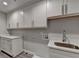 Bright laundry room features white cabinets and a stainless steel sink at 194 Jennifer Nw Ln, Lilburn, GA 30047