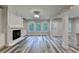 Open-concept living room with a fireplace, large windows, and a view of the backyard at 194 Jennifer Nw Ln, Lilburn, GA 30047