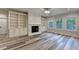 Bright living room featuring a fireplace, built-in bookshelves and cabinets, and wood-look flooring at 194 Jennifer Nw Ln, Lilburn, GA 30047