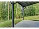 View of covered patio area with green grass, wooded backyard, and black support beams at 194 Jennifer Nw Ln, Lilburn, GA 30047