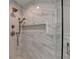 Close up of a walk-in shower featuring marble-style tiling, a shower niche, and chrome fixtures at 194 Jennifer Nw Ln, Lilburn, GA 30047