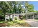 Charming single-story home with carport, red door, lush lawn, and mature trees at 2044 Glendale Dr, Decatur, GA 30032