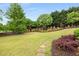Lush backyard featuring mature trees, manicured landscaping, and a stone pathway at 2855 Drayton Hall Dr, Buford, GA 30519