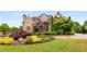 Beautiful brick home featuring professionally landscaped front yard with mature trees and colorful flower beds at 2855 Drayton Hall Dr, Buford, GA 30519