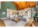 Open living room with a vaulted wood ceiling, stone fireplace, and seamless flow to the kitchen at 2855 Drayton Hall Dr, Buford, GA 30519