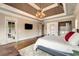 Bright main bedroom with a large bed, tray ceiling, chandelier, and access to a balcony at 2855 Drayton Hall Dr, Buford, GA 30519
