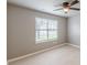 A light-filled bedroom featuring a modern ceiling fan, large window, and neutral color palette at 3022 Stonebridge Creek Dr, Lithonia, GA 30058