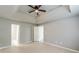 Spacious main bedroom featuring a tray ceiling with fan, light-colored walls and multiple doors at 3022 Stonebridge Creek Dr, Lithonia, GA 30058