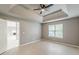 Spacious main bedroom featuring a tray ceiling with fan, light-colored walls and wood flooring at 3022 Stonebridge Creek Dr, Lithonia, GA 30058