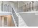 Elegant staircase featuring white painted wood and black iron railing leading to the second floor at 3022 Stonebridge Creek Dr, Lithonia, GA 30058