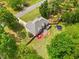 Picturesque aerial view showcasing a home with a spacious yard, wooden deck, playset, and surrounding greenery at 47 Centerport Dr, White, GA 30184
