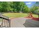Expansive backyard featuring a wooden deck, lush green lawn, and a charming playset, perfect for outdoor enjoyment at 47 Centerport Dr, White, GA 30184