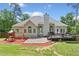 A spacious fenced-in backyard with lush green grass, wooden deck, playset, and wooded views at 47 Centerport Dr, White, GA 30184