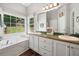 Bathroom features double sinks, hardwood floors, lots of natural light, and large tub at 47 Centerport Dr, White, GA 30184