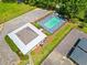 Aerial view of rectangular community pool and adjacent building with picnic tables, shrubs and foliage surround fenced area at 47 Centerport Dr, White, GA 30184