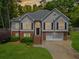 Charming two-story home featuring a brick and stucco facade, black shutters, and a well-manicured lawn at 47 Centerport Dr, White, GA 30184