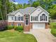 Charming two-story home featuring a brick and stucco facade, black shutters, and a well-manicured lawn at 47 Centerport Dr, White, GA 30184