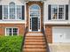 Home's front door with brick steps leading to an arched entryway, flanked by large windows at 47 Centerport Dr, White, GA 30184