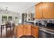 Well-lit kitchen with stainless steel appliances, sink, black countertops, and hardwood floors at 47 Centerport Dr, White, GA 30184