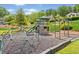 Community playground with climbing dome, tower with slides, and monkey bars on a bed of mulch and surrounded by green lawns at 47 Centerport Dr, White, GA 30184