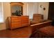 Comfortable bedroom with a dresser, large mirror, and relaxing chair in a naturally lit space at 1699 Little Fox Ln, Dacula, GA 30019