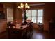 Elegant dining room featuring a chandelier, large windows, and a table for eight guests at 1699 Little Fox Ln, Dacula, GA 30019