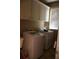 Efficient laundry room featuring a stacked washer and dryer, complemented by convenient overhead storage cabinets at 1699 Little Fox Ln, Dacula, GA 30019