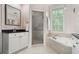 Bathroom with a glass-enclosed shower, soaking tub, and modern vanity at 190 Centennial Way, Atlanta, GA 30313