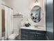 Bathroom features a gray vanity, toilet, shower with a curtain, and a mirror reflecting a bedroom at 190 Centennial Way, Atlanta, GA 30313