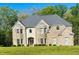 Stunning brick two-story home with a manicured lawn and lush surrounding greenery at 209 Kingscastle Dr, Ellenwood, GA 30294