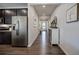 Bright hallway with dark wood floors, leading past the kitchen with stainless steel fridge to the front entrance at 34 Mountainbrook Nw Dr, Cartersville, GA 30121