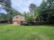 Exterior view of the home featuring a wooden deck, lawn, and lush trees, showcasing the backyard and outdoor space at 4135 Moore Rd, Conley, GA 30288