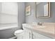Cozy bathroom features a framed mirror, toilet, and a sink next to a window at 855 Cedar Bluff Ct, Marietta, GA 30062