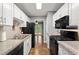 Stylish kitchen with white cabinets, granite countertops, black appliances, stainless steel sink and hardwood floors at 855 Cedar Bluff Ct, Marietta, GA 30062
