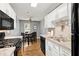 Bright kitchen with granite countertops, white cabinets, black appliances and a view of the dining area at 855 Cedar Bluff Ct, Marietta, GA 30062