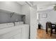 Functional laundry area with washer, dryer, storage shelf, and access to dining area at 855 Cedar Bluff Ct, Marietta, GA 30062
