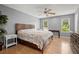 Spacious main bedroom has wood floors, ceiling fan, windows and a large bed at 855 Cedar Bluff Ct, Marietta, GA 30062