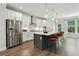 Modern kitchen boasts stainless steel appliances, a large island with seating, and stylish pendant lighting at 1327 Rosen Rd, Brookhaven, GA 30319