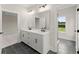 Modern bathroom features a double vanity with white countertops and sleek black fixtures, with gray tile flooring at 1419 Coretta Bnd, Atlanta, GA 30318